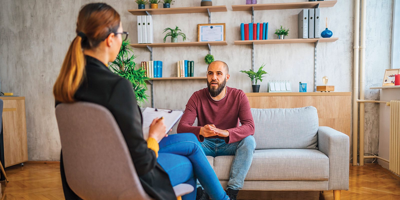 A man sitting on the couch talking to someone