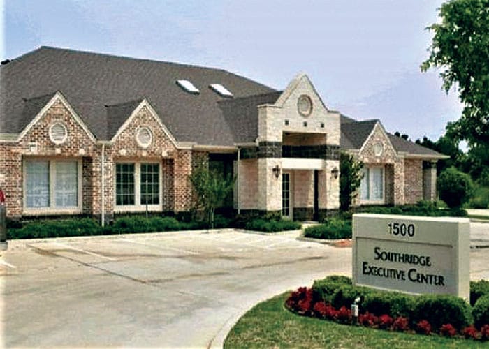 A large building with a sign in front of it.