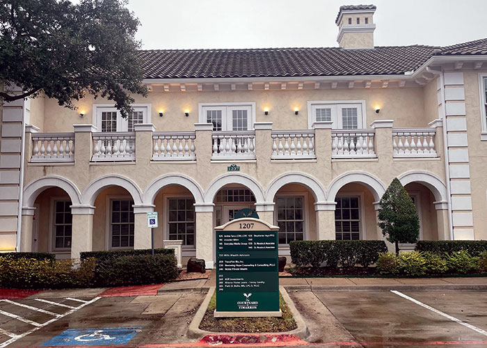 A large building with a bell in front of it.