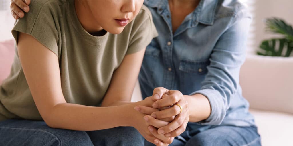 A woman holding her hands with another person.