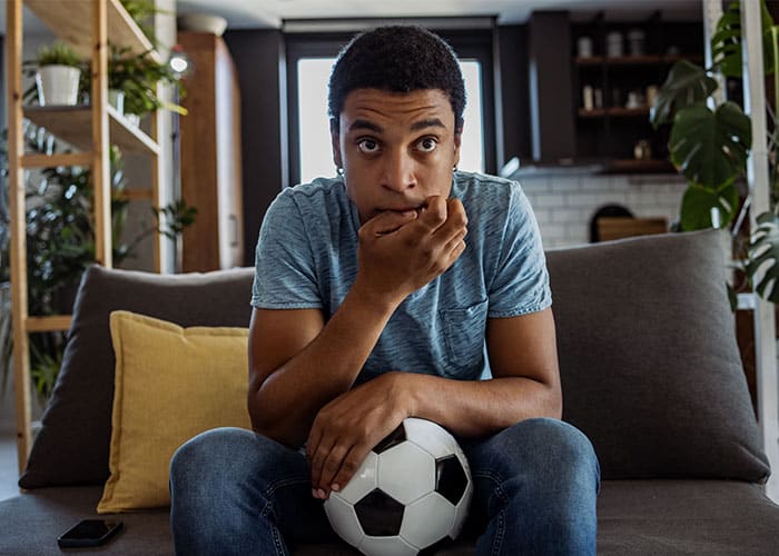 A man sitting on the couch with his mouth open.