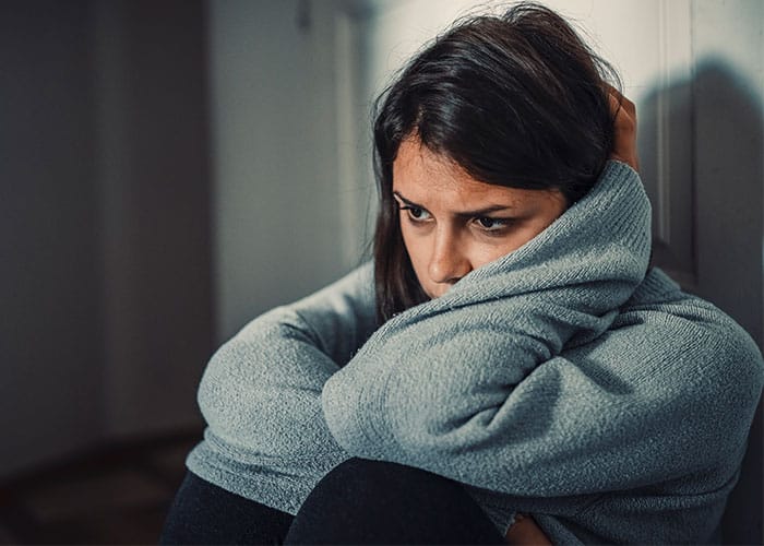 A woman wrapped in a blanket sitting down.