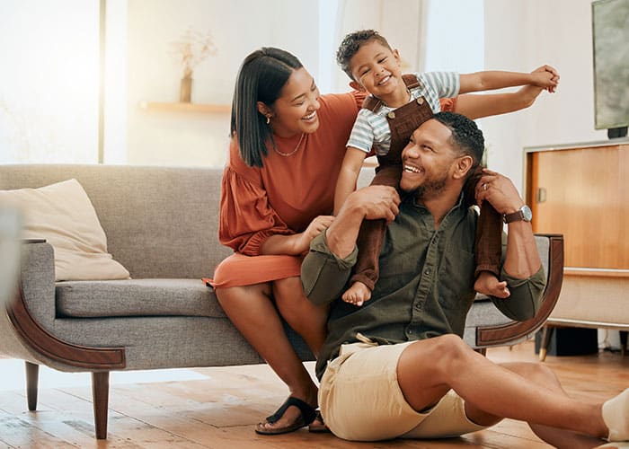 A man and woman sitting on the ground with a child.