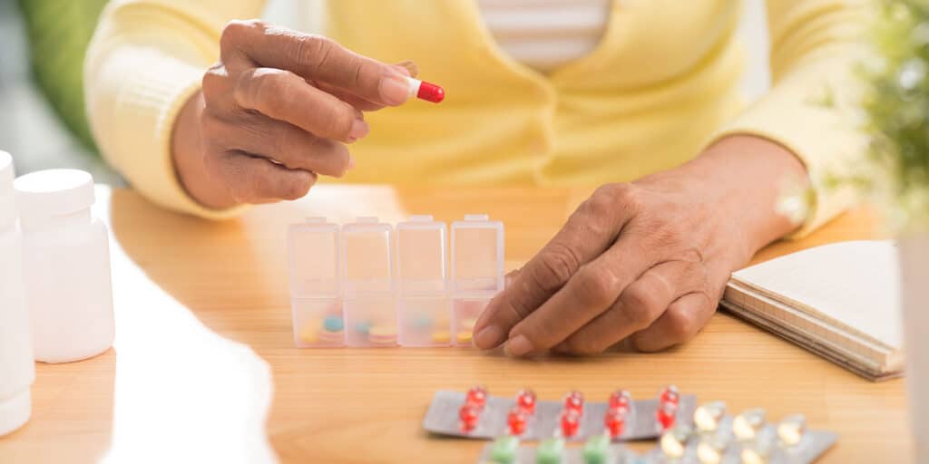 A person is putting pills in their hands.