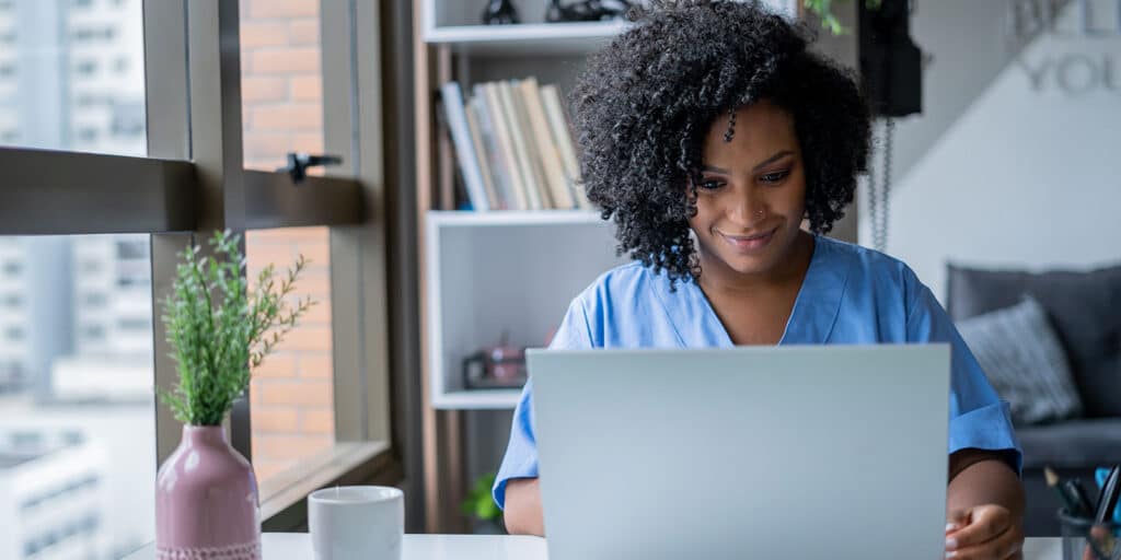 A woman sitting at a table with a laptop.