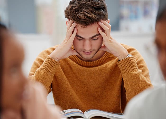 A man sitting in front of an open book.