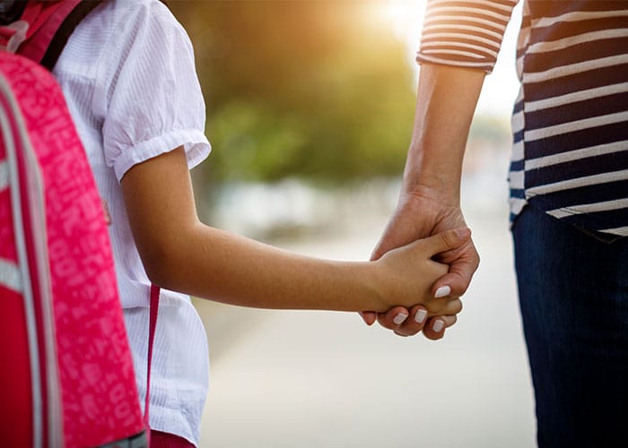 A close up of two people holding hands