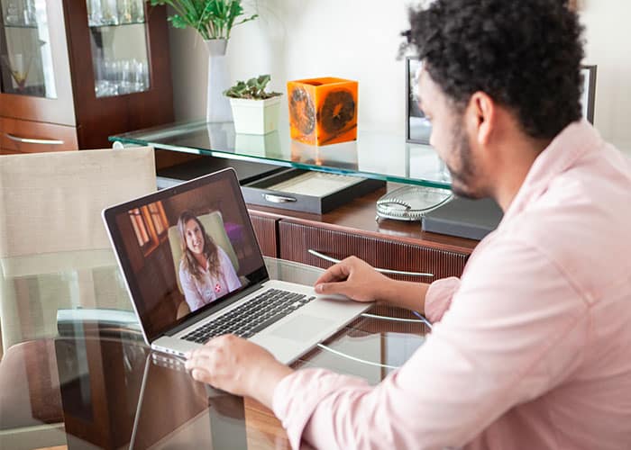 A man sitting at a table with a laptop.