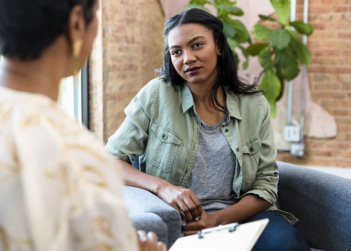 A woman sitting in front of another person.